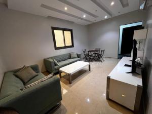 a living room with a couch and a table at شقة مخدومة 101 in Medina