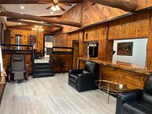 a living room with wooden walls and leather furniture at Beautiful cabin surrounded by nature in Catskill