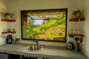 a kitchen with a sink and a window with a view at Somni Hill in Torio +17 photos