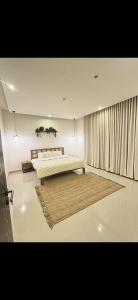 a bedroom with a large bed and a rug at Bohovibes in Buraydah