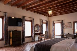 una camera da letto con letto, TV e finestre di Mirador del Frayle a San Miguel de Allende