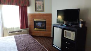 a hotel room with a bed and a flat screen tv at Baymont by Wyndham Helen in Helen