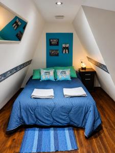 a bedroom with a blue bed with towels on it at Ushuaia Magnifica,cabaña con balcon,luminosa y calida in Ushuaia