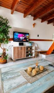 a living room with a flat screen tv and a table at Ushuaia Magnifica,cabaña con balcon,luminosa y calida in Ushuaia