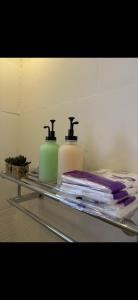 two bottles of soap and towels on a shelf at Bohovibes in Buraydah +10 photos