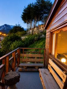 a porch of a wooden house with a window and stairs at Ushuaia Magnifica,cabaña con balcon,luminosa y calida in Ushuaia