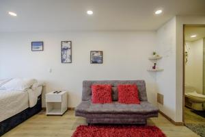 a bedroom with a bed and a couch with two red pillows at HOSTARA EDIFICIO CAPITALIA, El Cable, Manizales in Manizales +132 photos