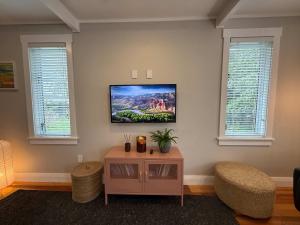 a living room with a tv on the wall at Maison Millie - Central Pet-Friendly Sleeps 4 in Rotorua +14 photos