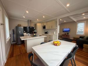 a kitchen with a table with a bowl of fruit on it at Maison Millie - Central Pet-Friendly Sleeps 4 in Rotorua