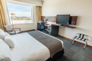 a hotel room with a bed and a desk and a television at MDS Hotel Concepción in Concepción