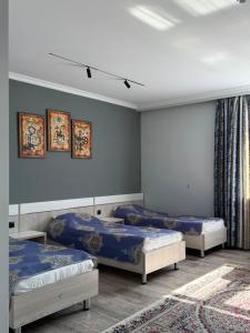 three beds in a room with blue walls at Saty Guest House in Saty