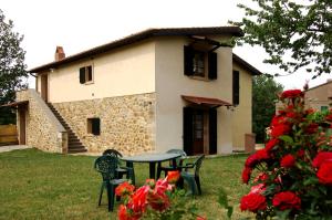 a table and chairs in front of a house at Agriturismo Pian Perugino in Arcidosso