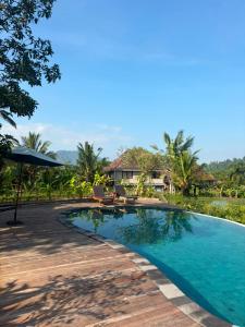 a pool at the resort with a view of the ocean at Embang Homestay in Sidemen