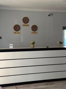 a white counter with three clocks on the wall at Saty Guest House in Saty