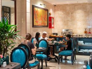 a group of people sitting at tables in a restaurant at Ritana Boutique Hotel & Spa in Hanoi
