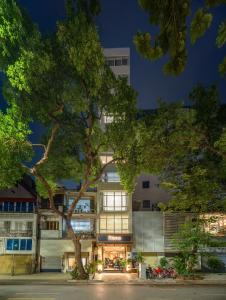 a building with a tree in front of it at Ritana Boutique Hotel & Spa in Hanoi