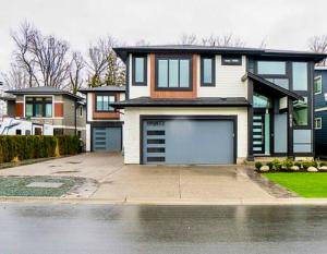 a house with a garage in front of a driveway at Fairway Retreat Chilliwack in Chilliwack