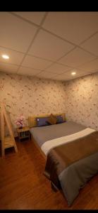 a bedroom with two beds and a wall with flowers at Valley homestay Dalat in Da Thien