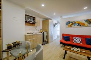 a living room with a red couch and a kitchen at HOSTARA EDIFICIO CAPITALIA, El Cable, Manizales in Manizales