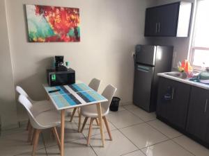 a kitchen with a table and chairs and a refrigerator at Beautiful Executive Apartment 1 in Guadalupe