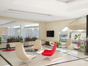 a lobby with chairs and a table and a tv at ibis Muscat in Muscat