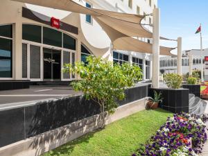 a view of the front of a building with flowers at ibis Muscat in Muscat