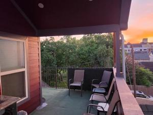 a patio with chairs and a balcony with a sunset at Houston Sweet Spot Townhouse in Houston