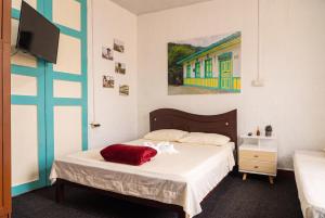 a bedroom with a bed with a red pillow on it at Hotel Casa Rosario in Circasia