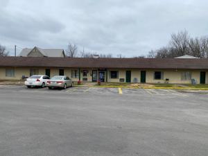 a building with two cars parked in a parking lot at Royal Inn in Albany