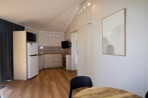 a kitchen with a table and a white refrigerator at Pine Country Caravan Park in Mount Gambier
