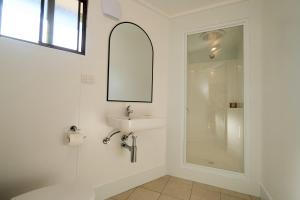 a white bathroom with a sink and a shower at Pine Country Caravan Park in Mount Gambier