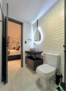 a bathroom with a white toilet and a sink at Flat Praiano Intermares Boutique in Cabedelo +18 photos