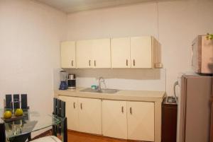 a kitchen with white cabinets and a glass table at Hotel Casa Rosario in Circasia