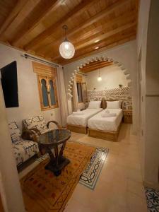 a living room with two beds and a table at Riad Nassar in Chefchaouen