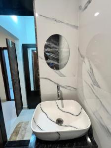 a white sink in a bathroom with a mirror at Lohith International in Shimoga