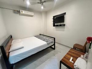 a small bedroom with a bed and a tv at Lohith International in Shimoga +10 photos