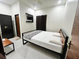 a bedroom with a bed and a television in it at Lohith International in Shimoga