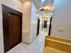 a hallway with a brown door and a hallway with a hallway at Lohith International in Shimoga