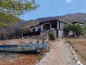 an old boat sitting in front of a house at brisas costeña in Santa Marta