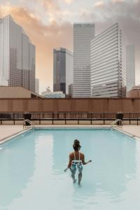 a man in a swimming pool with a city skyline at Sheraton Dallas Hotel in Dallas