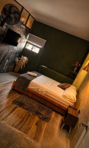 a bedroom with a bed with a green wall at Hotel Boutique Urban in San Gil