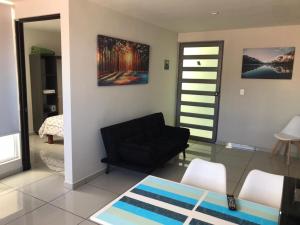 a living room with a black couch and a table at Beautiful Apartment Executive 3 in Guadalupe