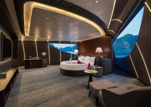 a hotel room with a bed and a large window at M'Gloria Cruise by HAG in Ha Long
