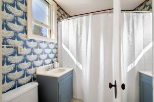 a bathroom with a sink and a shower curtain at Design-Forward | Steps to Shops & Dining | 2 Kings in Mill Valley +10 photos