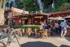 a man standing in front of a restaurant with tables and chairs at Design-Forward | Steps to Shops & Dining | 2 Kings in Mill Valley