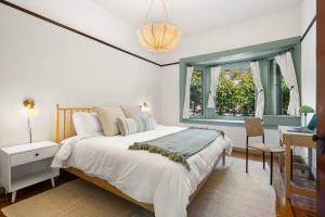 a bedroom with a bed and a desk and a window at Design-Forward | Steps to Shops & Dining | 2 Kings in Mill Valley