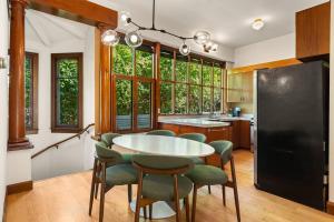 a kitchen with a round table and green chairs at Design-Forward | Steps to Shops & Dining | 2 Kings in Mill Valley