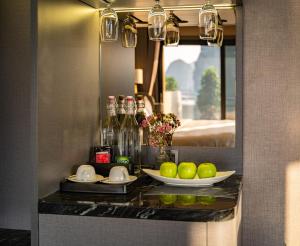 a vanity with a plate of fruit on a counter in a room at M'Gloria Cruise by HAG in Ha Long