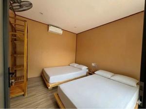 a room with two beds and a ladder in it at Đảo Ngọc Retreat in Quang Ninh