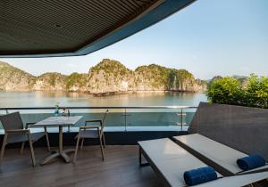 a balcony with a table and chairs and a view of a river at M'Gloria Cruise by HAG in Ha Long